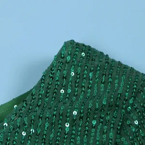 Close-up of green sequins on mesh fabric showing intricate detail and texture.
