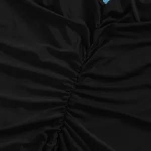 Macro view showing the fine ruched texture and stitching of a black bodycon dress