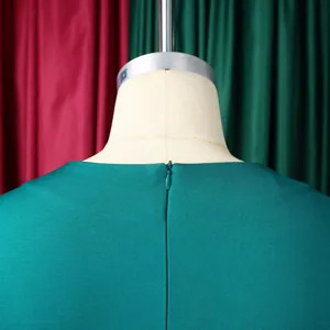 Détail du dos d'une robe vert foncé avec une fermeture éclair invisible discrète