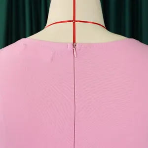 Detail van de onzichtbare rugrits en halslijn van een modieuze roze jurk voor dames