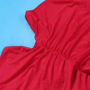 Close-up detail of red pleated stretch fabric on a sexy strapless floor-length dress.