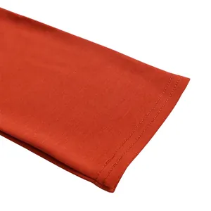 Detaillierte Ansicht eines orangefarbenen gerippten Kleidärmels mit Doppelnähten.