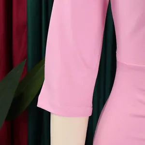 Detailopname van roze mouw en taille van een stijlvolle geplooide kokerjurk