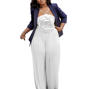 Detail of white pleated jumpsuit with large floral embellishment and navy blue blazer