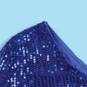 Macro detail of shimmering purple sequins on mesh fabric of a one-shoulder dress.