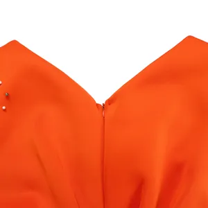 Close-up of the V-neckline and hidden zipper on this orange beaded evening dress