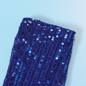 Close-up view of the sparkling blue sequins on dark purple mesh dress fabric texture