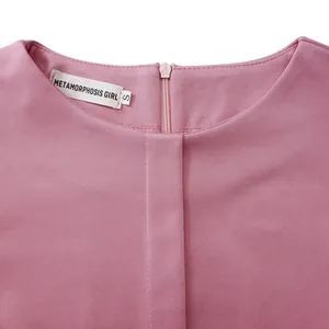 Macro détaillée de l'encolure d'une robe crayon rose avec étiquette de marque et zip