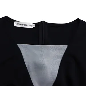 Close-up detail of back zipper and grey mesh inset on a black wide-leg jumpsuit.