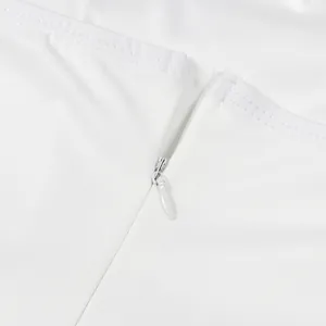 Detailansicht des hochwertigen verdeckten Reißverschlusses am weißen Jumpsuit-Stoff