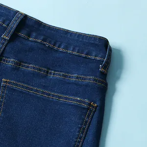 Dettaglio delle cuciture a contrasto di alta qualità su jeans a zampa elasticizzati blu scuro