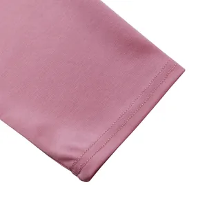 Gros plan sur les coutures soignées et le tissu rose d'une robe africaine.