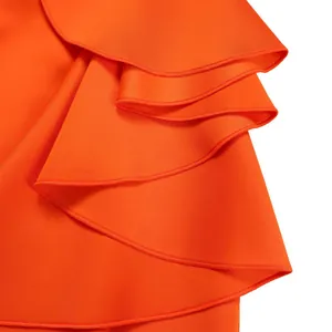 Detailed macro view of vibrant orange layered ruffle flounce on an elegant evening gown