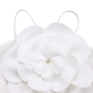 Detailed view of the oversized 3D flower applique on the chest of a white jumpsuit