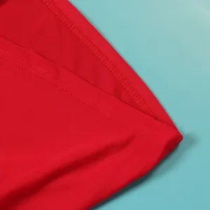 Close-up detail of high-quality red elastic fabric seam and stitching on a dress.