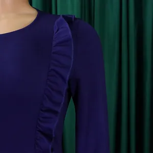 Détail d'une robe crayon bleu marine moulante avec des volants élégants à l'épaule