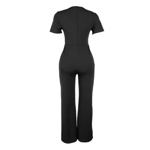 Vista posteriore di elegante tuta nera a maniche corte con vita alta e pantaloni a gamba larga.