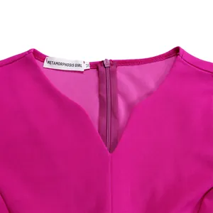 Détail rapproché du col en V et de l'étiquette sur une robe plissée magenta