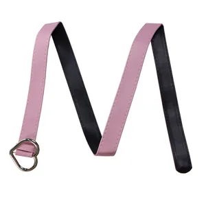 Vue détaillée de la ceinture réversible rose et noire en similicuir avec boucle cœur argent