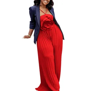 Full view of a red pleated jumpsuit with a large 3D flower detail and a navy blazer.