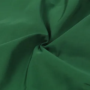 Nahaufnahme des hochwertigen dunkelgrünen Stoffes mit weichem Faltenwurf und Textur