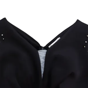Close-up of black V-neck evening dress with pearl beadwork and zipper detail