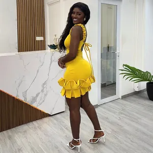 Vista trasera de un vestido amarillo ajustado con dobladillo con volantes y lazo en la espalda.