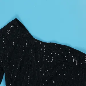 Detailed macro view of black sequins and mesh texture on a sexy one-shoulder dress