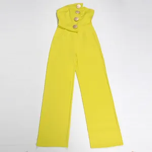 Makroansicht des gelben ärmellosen trägerlosen Jumpsuits mit eleganten Goldknöpfen.