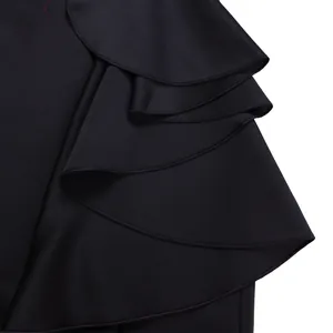 Macro close-up of tiered ruffle detailing on a luxury black V-neck evening gown.