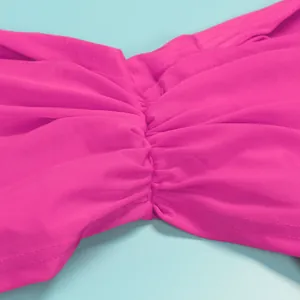 Macro detailed view showing ruched pleats on fuchsia pink elastic fabric two-piece set
