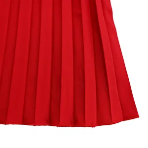 Close-up detail of high-quality red pleated fabric with fine stitching on garment hem
