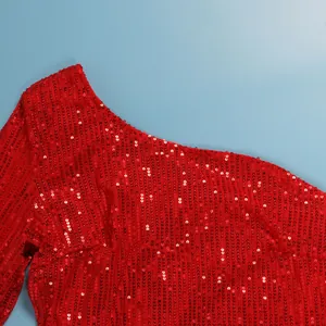 Close-up detail of a red sequined one-shoulder dress showing shimmering metallic texture.