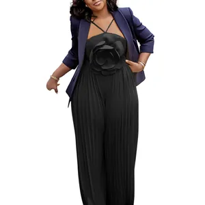 Detail of elegant black pleated jumpsuit featuring 3D flower detail and navy blazer