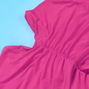 Close-up detail of magenta stretch fabric showing fine elasticized pleats on a maxi dress