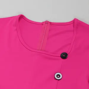 Dettaglio dello scollo irregolare e dei bottoni di una tuta fucsia a gamba larga.