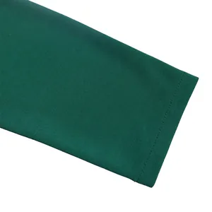 Gros plan sur la texture de la manche en maille vert émeraude d'une robe crayon élégante