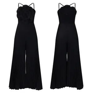 Front and back view of a chic black jumpsuit with a large 3D flower and pleated legs.