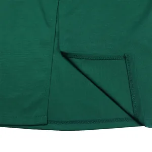 Gros plan de l'ourlet d'une robe crayon vert foncé avec couture de qualité et fente.