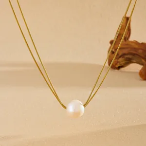 Gros plan d'une perle d'eau douce sur un collier double rang doré en maille serpent