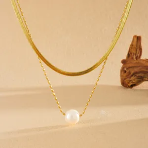 Détail d'un collier double en acier inoxydable doré orné d'une perle d'eau douce