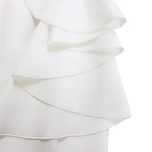 Detail shot of elegant white evening dress featuring multi-layered cascading ruffles