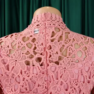 Close-up detail of high-neck pink lace jumpsuit with intricate floral patterns