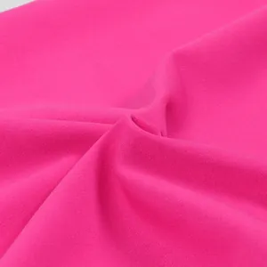 Dettaglio macro ravvicinato della trama del tessuto rosa magenta per tute eleganti.