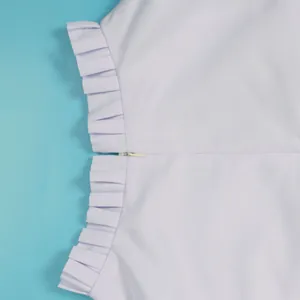 Detailansicht einer weißen Weste mit verdecktem Reißverschluss und eleganten Rüschen