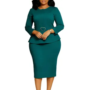 Détail de robe péplum verte à col rond avec ceinture à boucle en forme de cœur.