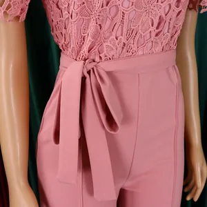Detailed close-up of pink lace hollow-out jumpsuit featuring an elegant waist tie belt