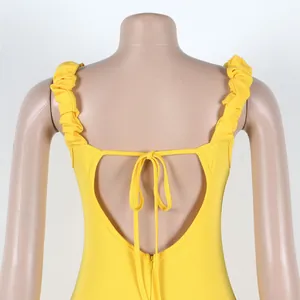 Detalle de vestido amarillo con tirantes de volantes, espalda abierta de corazón y lazo