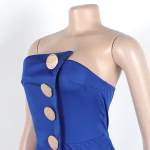 Nahaufnahme eines blauen trägerlosen Jumpsuits mit großen goldenen Zierknöpfen auf der Vorderseite