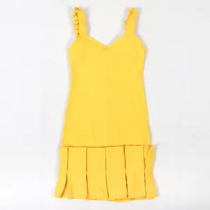 Vista detallada de vestido amarillo ajustado con tirantes rizados y dobladillo plisado.